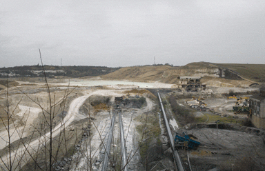 A conveyor rising from the quarry floor. On the horizon are the UK’s tallest pylons A conveyor rising from the quarry floor. On the horizon are the UK’s tallest pylons